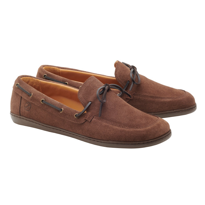 Ein Paar Schuhe QEA Velours Brown von ZAQQ mit dunkelbraunen Schnürsenkeln und Nähten sowie einem Logo an der Seite. Sie bieten einen lässigen Slip-On-Stil mit Gummisohlen für zusätzlichen Komfort.