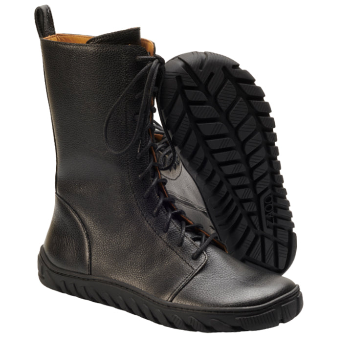 Präsentiert wird ein Paar DOQS Black Boots von ZAQQ, hergestellt aus hochwertigem Nappaleder und mit einer strapazierfähigen ULTRAGRIP-Sohle. Ein Stiefel steht aufrecht, während der andere geneigt ist, um das detaillierte Profilmuster auf der Sohle zu zeigen und die strukturierte, lederähnliche Oberfläche hervorzuheben.