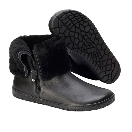 Wir präsentieren den HUQ Winter Black von ZAQQ: ein Paar schwarze Stiefeletten, fachmännisch aus hochwertigem Nappaleder gefertigt, komplett mit kuscheligem Fellfutter und praktischem Reißverschluss an der Seite. Ein Stiefel steht aufrecht, während der andere leicht geneigt ist und das strukturierte Griffmuster seiner Kautschuksohle perfekt zur Geltung bringt.