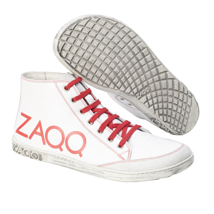 Die SQYLA White High-Top-Sneaker von ZAQQ sind eine moderne Option mit auffälligen roten Schnürsenkeln und Nähten sowie dem rot aufgedruckten Markennamen ZAQQ an der Seite. Die Schuhe verfügen über strukturierte Sohlen für hervorragenden Halt, die stilvoll zur Schau gestellt werden, indem ein Schuh verkehrt herum präsentiert wird, um sein unverwechselbares Profilmuster hervorzuheben.