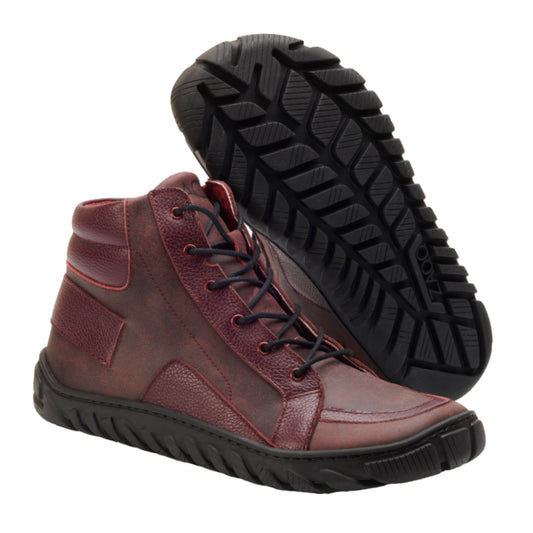 Der OSQAR Bordeaux von ZAQQ ist ein Paar kastanienbraune High-Top-Sneaker mit schwarzen Schnürsenkeln und einer strukturierten ULTRAGRIP-Sohle mit markantem Profilmuster. Perfekt für alle, die die Vorteile von Barfußschuhen schätzen, kombinieren diese Schuhe Stil mit Funktionalität vor einem schlichten weißen Hintergrund.