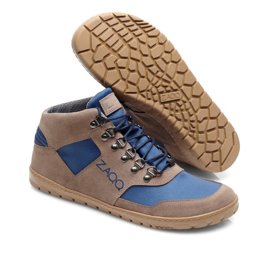 Ein Paar ZAQQ HIQE Mid Ocean Waterproof High-Top-Sneakers hat ein stilvolles blau-braunes Design mit beigen Sohlen. Ein Schuh steht aufrecht und zeigt wunderschön die blaue Spitze und die Seitenteile mit braunen Akzenten, ideal für ein Barfußschuh-Erlebnis. Der andere Schuh ist geneigt, um das strukturierte Sohlendesign und den Schnürverschluss hervorzuheben.