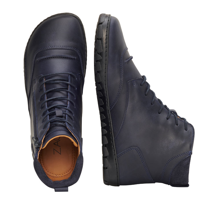 Wir präsentieren die ZAQQ PARQER Navy High-Top-Schuhe in einem satten Dunkelblau. Diese Barfuß-Schuhe sind mit Schnürsenkeln, einem seitlichen Reißverschluss und einer strukturierten schwarzen Gummisohle ausgestattet. Sie sind aus hochwertigem Nappaleder mit einem braunen Innenfutter gefertigt und bieten sowohl Stil als auch Komfort aus jedem Blickwinkel.