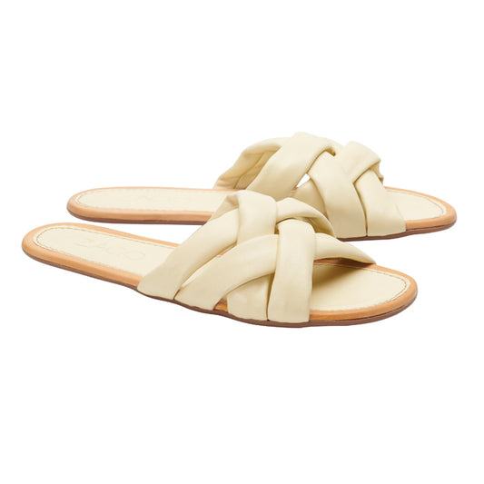 Das Modell ALAQ Beige von ZAQQ ist ein Paar Slip-On-Sandalen mit geflochtenen Riemen und flacher Kautschuksohle auf weißem Hintergrund.