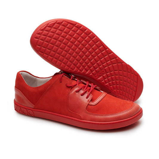 Ein Paar leuchtende IVIQ Red-Sneaker von ZAQQ, einer steht aufrecht und der andere liegt auf der Seite und zeigt die Sohle mit Waffelmuster. Diese modischen Schuhe zeichnen sich durch ein Schnürdesign mit einer Kombination aus Wildleder und Leder aus.