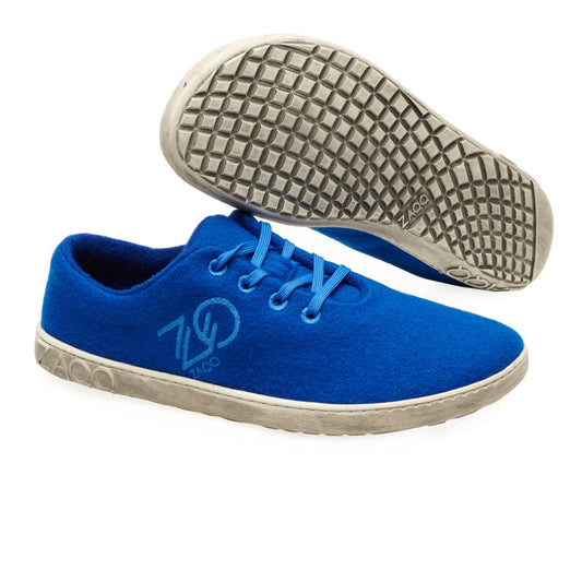 Die LIQE Azur Sneaker von ZAQQ zeichnen sich durch ein elegantes Design mit blauem Obermaterial und weißer Sohle aus, akzentuiert durch ein Logo an der Seite. Diese Sneaker sind für den Komfort ähnlich wie Barfußschuhe konzipiert und verfügen über blaue Schnürsenkel. Ein Sneaker wird in einer Seitenansicht gezeigt, während der andere seine strukturierte Sohle nach vorne zeigt.