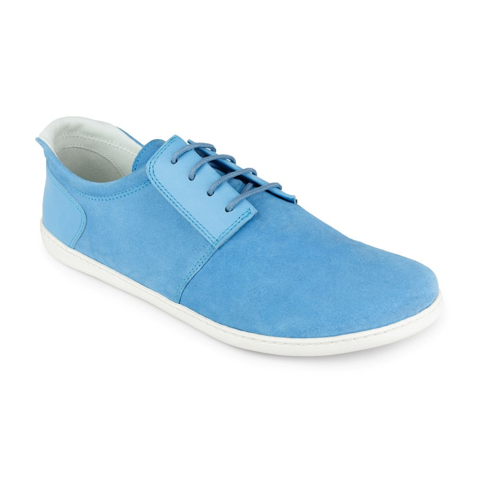 Ein einzelner PIQUANT Azure Sneaker von ZAQQ, gefertigt aus hellblauem Veloursleder mit weißer Sohle und blauen Schnürsenkeln. Der Schuh ist nach links geneigt, was sein glattes und minimalistisches Design unterstreicht.