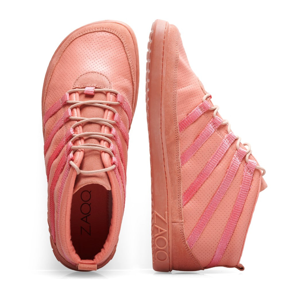 Die SPARQ Mid Rosa Sneaker von ZAQQ sind in Pink gehalten und aus Premium Nappaleder gefertigt. Ein Schuh steht aufrecht und zeigt seitliche Details mit rosa Streifen und Schnürsenkeln, während der andere auf die Seite gelegt ist, um die strukturierte Sohle und das ZAQQ-Branding hervorzuheben. Beide Barfußschuhe weisen perforierte Muster auf.